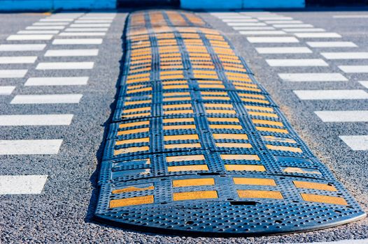 Yellow and Black Speed Bump on asphalt.