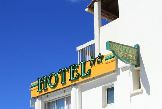 Small two stars hotel and restaurant signs on white building by beautiful day