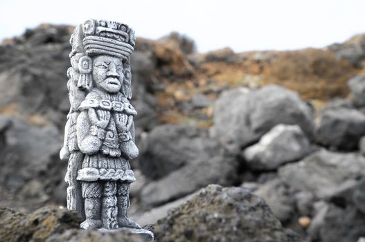 Ancient Maya Statue on the Rocks near the Ocean