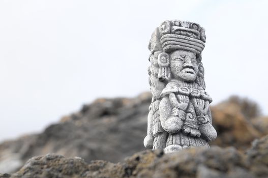 Ancient Maya Statue on the Rocks near the Ocean