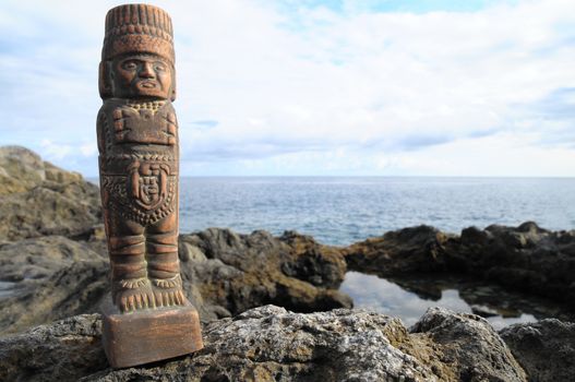 Ancient Maya Statue on the Rocks near the Ocean