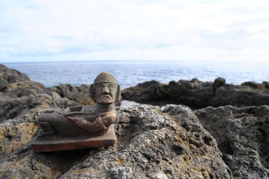 Ancient Maya Statue on the Rocks near the Ocean