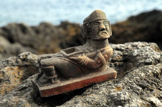 Ancient Maya Statue on the Rocks near the Ocean