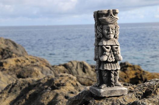 Ancient Maya Statue on the Rocks near the Ocean