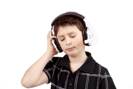 Portrait of a happy young boy listening to music on headphones against white background 