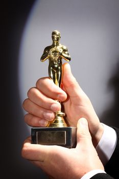 The winner holds in his hand the award. Fake Oscar prize