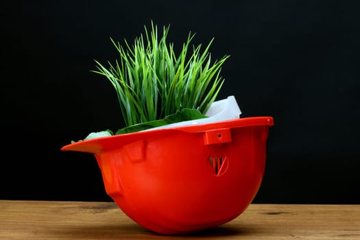 Green grass and red helmet- environmental friendly industry concept 