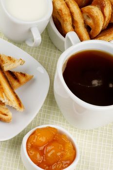 Coffee Break with Milk, Toasts, Apricot Jam and Puff Pastry closeup on Checkered background