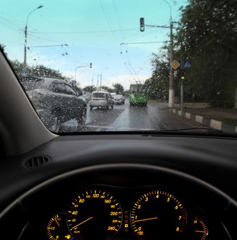 rain droplets on car windshield, traffic in city