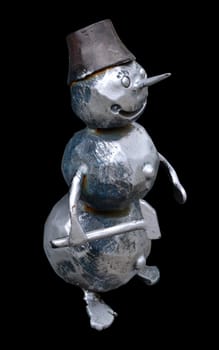 The isolated forged metal snowman with a hammer on a black background