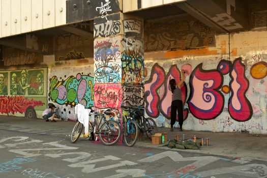 Girls painting the Graffiti on the walls along the Donaukanal (Danube Canal), Vienna Downtown, Austria