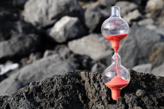 Time Concept - Hourglass Abandoned on the Volcanic Rocks