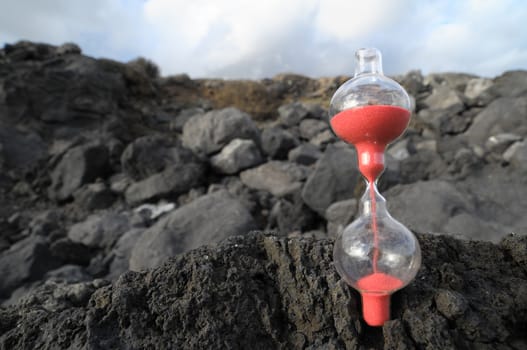 Time Concept - Hourglass Abandoned on the Volcanic Rocks