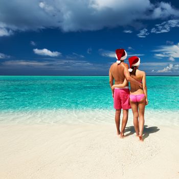 Couple in santa's hat on a tropical beach at Maldives