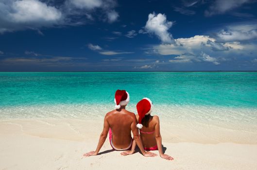 Couple in santa's hat on a tropical beach at Maldives