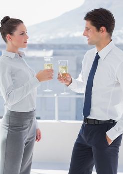 Business people clinking their flutes of champagne in their office