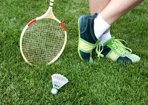 foot of badminton player who stays on grass