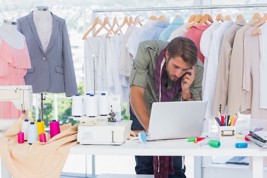 Fashion designer using laptop and calling