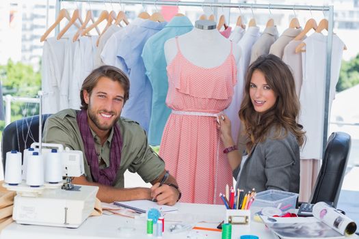 Fashion designers smiling to the camera in a bright creative office