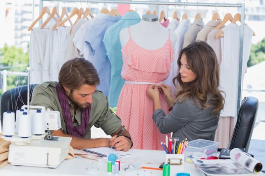 Fashion designers working together on a dress