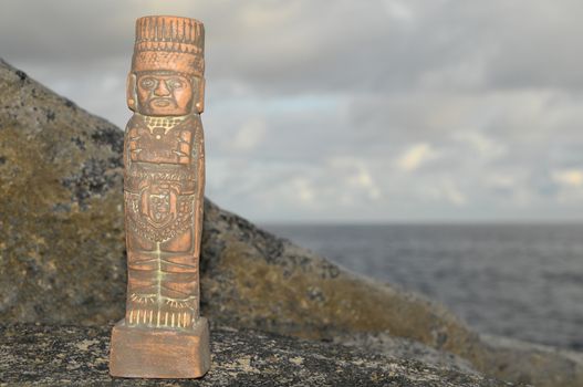 Ancient Maya Statue on the Rocks near the Ocean