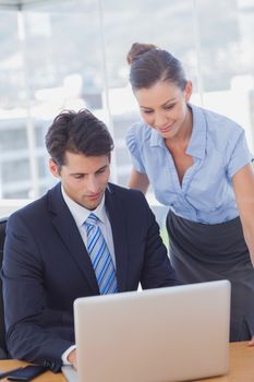 Business people smiling and working together with a laptop in the office