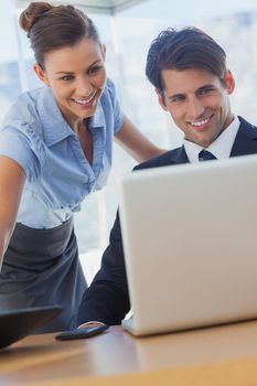 Business people looking the laptop and smiling in the office 