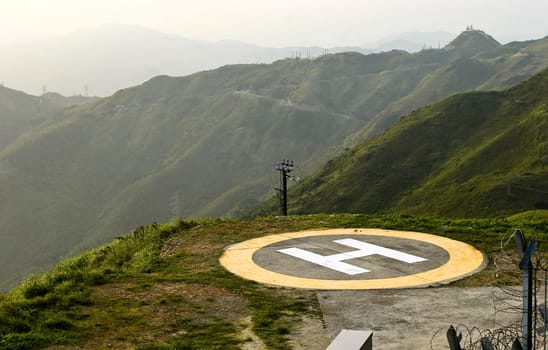 A peak helipad under sunset