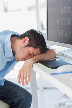 Graphic designer sleeping on his keyboard in his office
