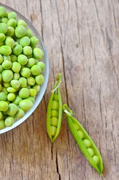 Fresh green peas on an old wooden background shoot in studio