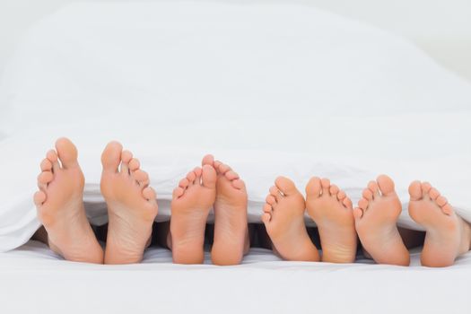 Family on the bed showing their barefoot