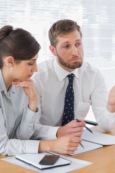 Business people chatting over documents at desk in office
