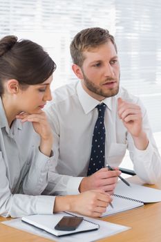 Business people discussing documents at desk in office