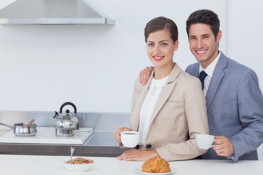 Couple of business people having breakfast with coffee and croissants