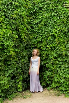 girl in a white dress on a background of leaves