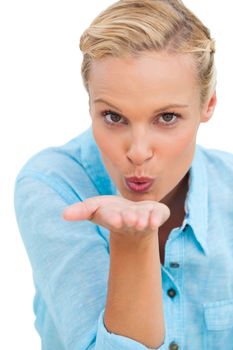Happy blonde woman blowing kisses on white background
