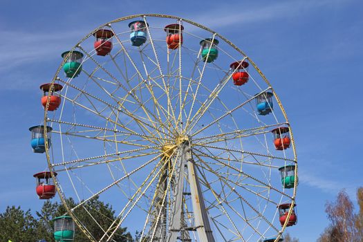 Atraktsion colorful ferris wheel against the blue sky