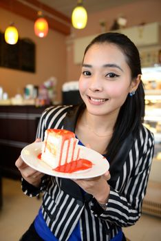 The beautiful smiling asian young woman with a cake