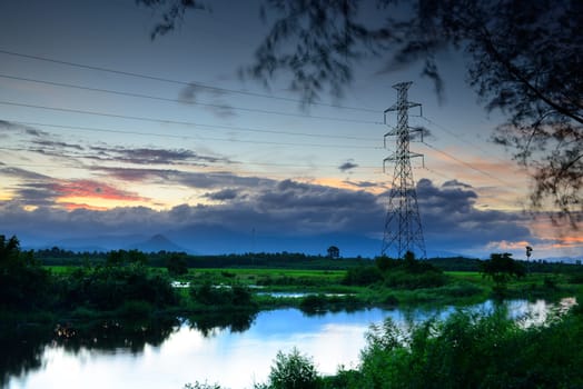 landscape high voltage post at sunset and mountain