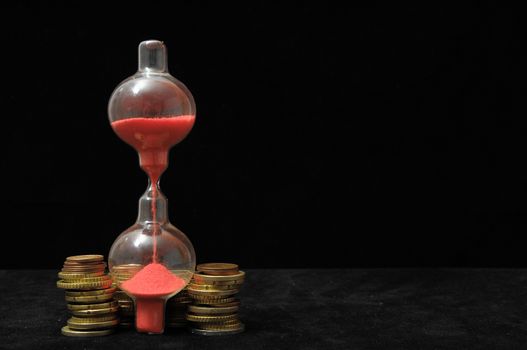 Business Time Concept Money and Hourglass on a Black Background