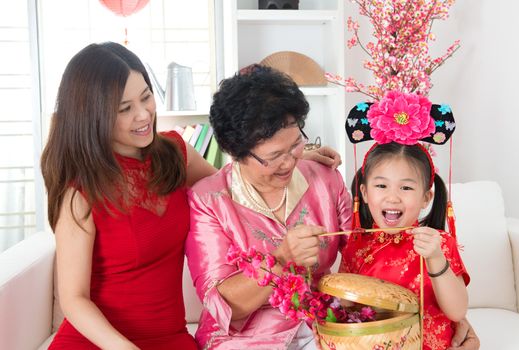 Beautiful grandchild visiting grandparent with gift during Chinese new year festival.