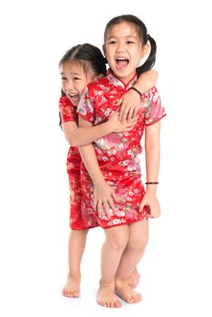 Beautiful oriental Asian girls in traditional Chinese cheongsam playing, full length isolated on white background