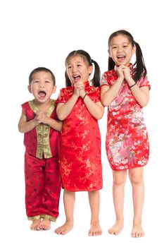 Little oriental children wishing you a happy Chinese New Year, with traditional Cheongsam standing isolated on white background.