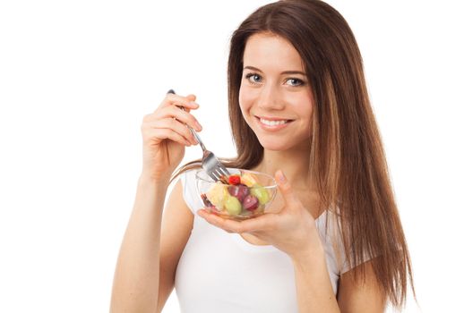 Nice young woman eating fruits and smiling, isolated on white