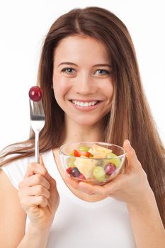 Close up portrait of a beautiful woman eating fruits, isolated on white