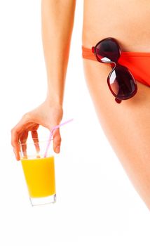 Female body wearing a bikini, sunglasses and hand holding a glass of orange juice, isolated on white