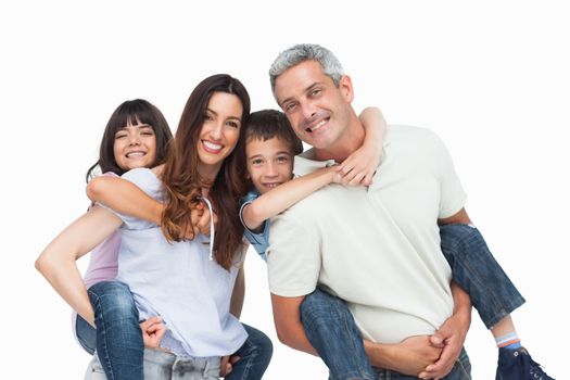 Smiling parents holding their children on backs on white background