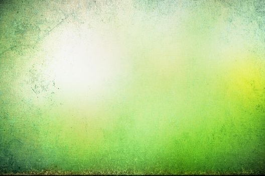 Abstract grungy bordered background texture with appearance of glowing yellow sunlight in a misty green forest glade.