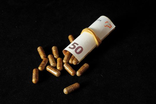 Some Pills And Money on a Black Background