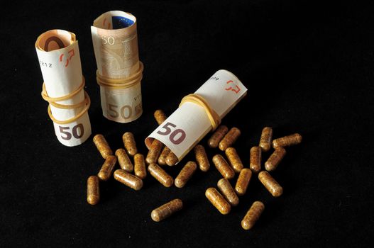 Some Pills And Money on a Black Background